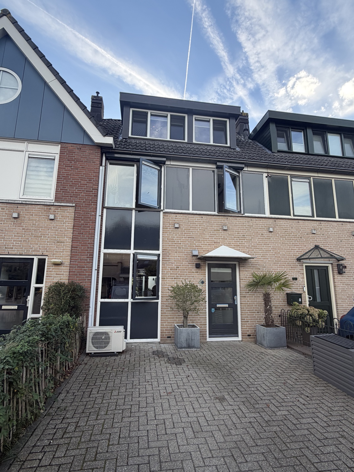 Woning met donkere gevelpanelen en een dakkapel