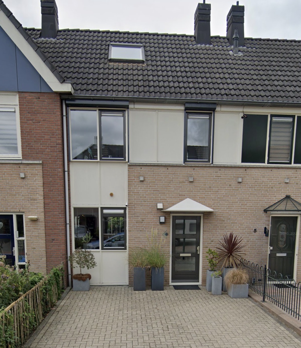 Woning met lichte gevelpanelen en buitenkozijnen